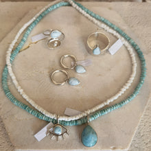 Load image into Gallery viewer, Jewelry set with necklace, rings, and earrings with larimar on a textured surface
