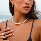 Soulshine Gems jewelry worn by a beautiful woman in black swimsuit  - wearing manta pendant and pearl chocker necklace , Kyanite earrings on round silver hoops, Kyanite and pearl spiral ring , pearl ring silver and silver ocean ring.