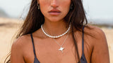 Soulshine Gems jewelry worn by a beautiful woman in black Buddha Wear swimsuit  and with freediving mask - wearing manta pendant and pearl chocker necklace , and Kyanite earrings on round silver hoops.