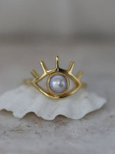 Load image into Gallery viewer, Gold ring in shape of eye with a freshwater pearl on a shell
