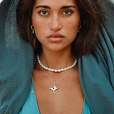 Soulshine Gems jewelry worn by a beautiful woman in turquoise aqua swimsuit  - wearing manta pendant and pearl chocker necklace , and Kyanite earrings on round silver hoops.